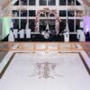 WHITE ACRYLIC FLOOR WITH MIRRORED FACADE AND GOLD MONOGRAM